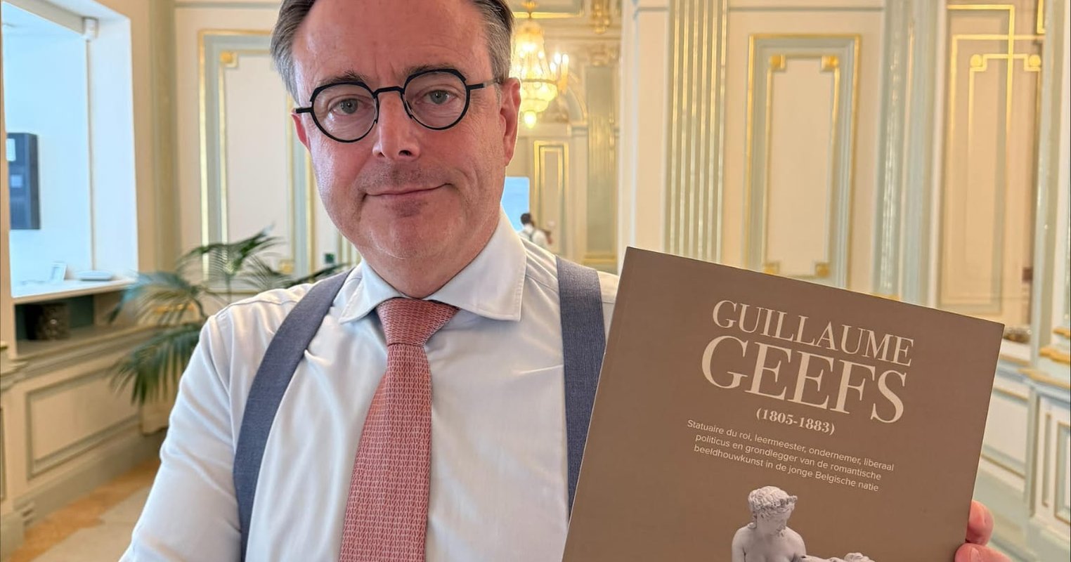 Premier Bart de Wever met het boek van Frederik Tinck over Guillaume Geefs