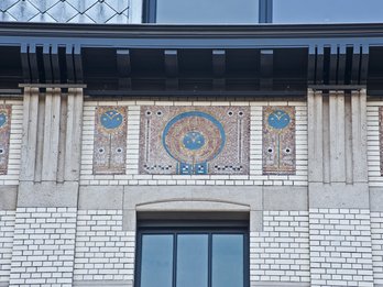 Motief in mozaiek in de gevel